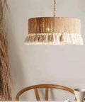 YAXDQUW Nordic Style Hemp Rope Pendant Light Hand‑Woven Cotton Tassel Shade Boho Hanging Ceiling Lamp above wooden table.