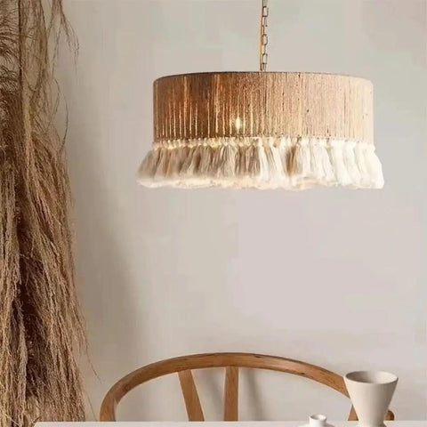 YAXDQUW Nordic Style Hemp Rope Pendant Light Hand‑Woven Cotton Tassel Shade Boho Hanging Ceiling Lamp above wooden table.
