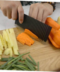SOLUSTRE wavy chopper knife crinkle slicer, stainless steel; side view slicing carrot on cutting board.