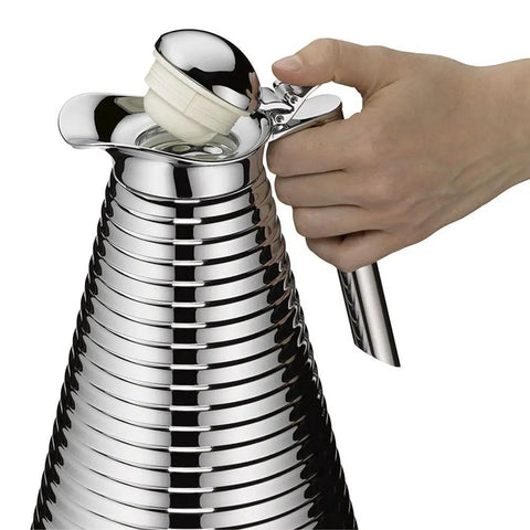 Hand pouring from Glass Vacuum Copper Carafe With Chrome Plated Spout And Stainless Steel Handle Keeps Hot For 12 Hours And Cold For 24
