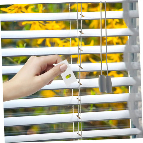 Hand applying Vertical Blind Repair Tabs Pack Of 50 For Easy Replacement Fixers With Quick Repairs Multimaterial Compatible Tabs.