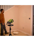 Man using Hybrid LED Work Light With Color Range 2700K To 5000K, 18V One Plus Compatible, mounted on a tripod indoors