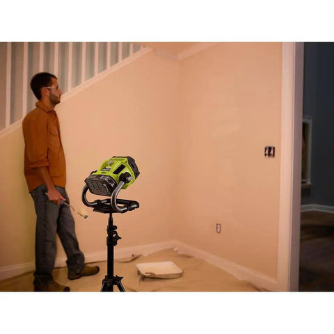 Man using Hybrid LED Work Light With Color Range 2700K To 5000K, 18V One Plus Compatible, mounted on a tripod indoors