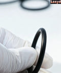 Close-up of a gloved hand holding an O-ring from Two Kit Pack Radiator Hose T Pipe O Ring Set For Ford F150 5.0L Mustang.