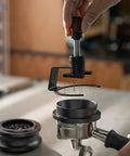 Game Changing 58mm Espresso Puck Distributor Tool with Adjustable Height and Eight Precision Needles in use over a portafilter.