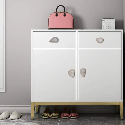 Upgrade Your Cabinets And Dressers With These Slick Natural Agate Slice Geode Drawer Knobs Featuring Plated Gold Edges And Heavy Duty Brass Screws For A Massive Kitchen Glow Up on a white cabinet.