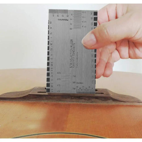 Hand holding a string action gauge from 17 Pcs Guitar Luthier Tools Kit With Notched Radius Gauges And Understring Radius Gauges.