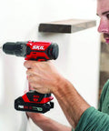 Man using 4 Tool Power Kit With 20V Cordless Drill Driver Impact Driver Reciprocating Saw And LED Spotlight Includes Two 2Ah Batteries And Charger For Home DIY Projects on wall