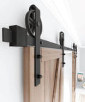 Black Wood Double Sliding Barn Door Hardware Kit With Big Spoke Wheel Rollers installed on wooden door frame