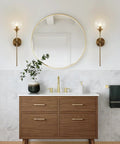 Glass Globe Wall Sconce In Brushed Brass With Clear Globe Mid Century Modern Bedroom Bedside Lighting Long Pole Nordic Style Wall Lamp For Living Room And Bathroom Decor And Accent Lighting Dope Vibe installed in a bathroom with a large round mirror.