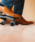 Top Shelf 2 Inch Antique Brass Swivel Casters With Heavy Duty Ball Bearings 4 Piece Furniture Wheel Set seen in use under a shoe