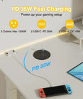 Three Inch Desktop Power Grommet With 35W USB C Fast Charging And Dual 18W USB A Outlets Black Six Foot Cord on desk with devices.