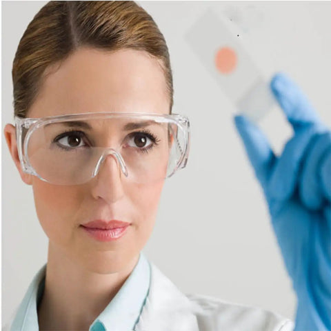 Scientist wearing 2 Pairs Dustproof And Splashproof Louvered Safety Goggles For Construction, Lab, And Chemistry Use With Wraparound Protection, Impact Resistant Polycarbonate Lenses, UV Resistant Coating, Comfortable And Secure Fit, examining a slide.