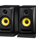 Classic 5 Inch Powered Studio Monitor Pair With Accessory Pack Delivering Pro Grade Sound For Home Studio Mixing Includes Two 10 Foot XLR Cables And Isolation Pads, showing black and yellow monitors on pads.