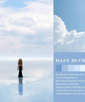 Person in black dress stands on reflective water with clouded sky background in haze blue theme