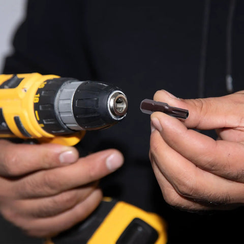 Heavy Duty T20 Torx Screwdriver Bits With Rock Solid Magnetic Security Heads And Snug 1/4 Inch Hex Shank Made From Top Shelf S2 Steel For A Dang Strong Hold On Every Fastener In This Sweet 24 Piece Bit Set held by a person with a drill.