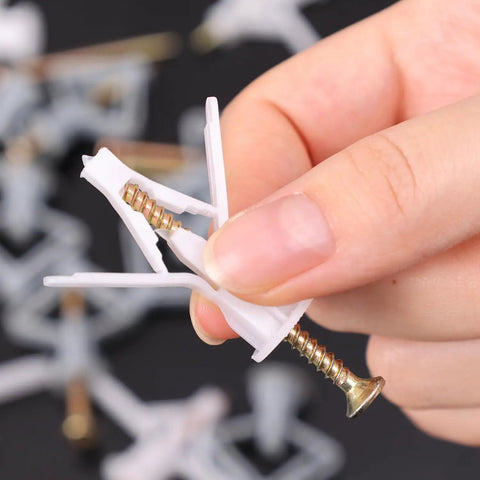 Hand holding Airplane Butterfly Gypsum Board Expansion Screws Kit For Hollow Walls And Plasterboard Nylon And Stainless Steel Self Drilling Fixings For Hanging Curtains Lights Frames And Decor