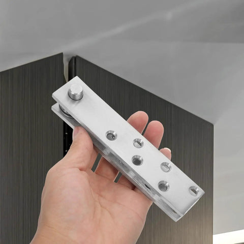 Hand holding Heavy Duty Stainless Steel Concealed Door Hinge For Bookcase Doors with visible holes and pivot points