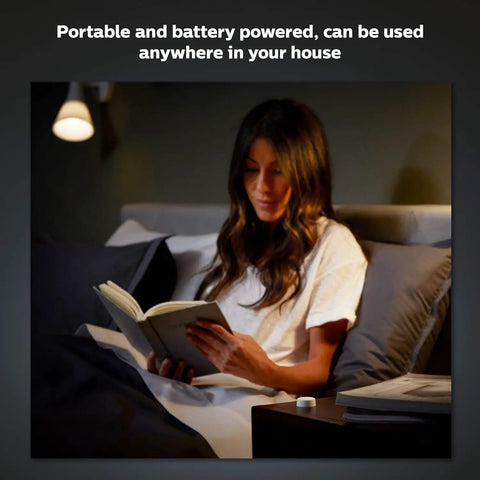 User reading book in bed with Wireless Smart Light Switch Button Battery Powered And Portable White Remote on nightstand