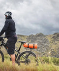 Cyclist with Spider Rear Rack And Bar Cradle For MTB And eMTB Quick Release Bike Rack System, carrying gear in mountainous terrain