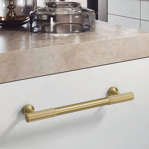 Brushed Gold Modern Kitchen Cabinet Handles Set 5 Pack Solid Brass Drawer Pulls installed on a white kitchen cabinet drawer.