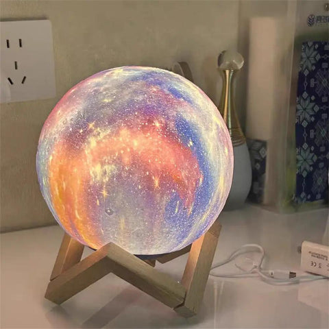 Galaxy Moon Lamp 4.8 Inch With Wood Stand, 16 Color Changing LED Moon Light glowing on desk with USB charging cable