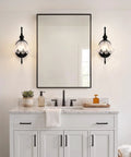 PUMING Black Wall Sconces Set of Two illuminating a modern bathroom with flower glass shades, mounted beside a mirror.