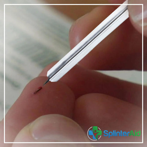Painless Splinter Removal Kit: close-up of white plastic tool with slim metal tip removing a splinter from finger; SplinterAid.