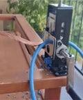 Essential 1 Pc Portable Wire Stripper For Electricians attached to wooden table, stripping cable with blue plastic tubing.