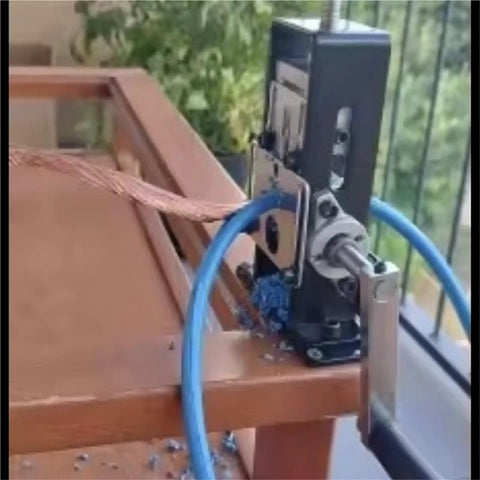 Essential 1 Pc Portable Wire Stripper For Electricians attached to wooden table, stripping cable with blue plastic tubing.