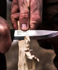 Companion Carbon Steel Fixed Blade Knife With Sheath 4.1 Inch Blade Military Green carving wood, showing 1095 carbon steel blade in use.