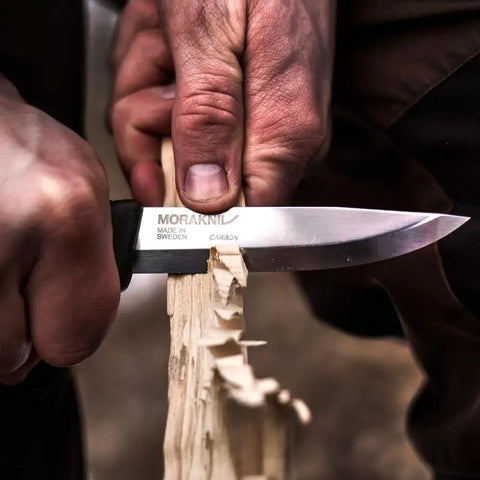 Companion Carbon Steel Fixed Blade Knife With Sheath 4.1 Inch Blade Military Green carving wood, showing 1095 carbon steel blade in use.