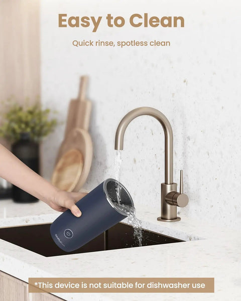 Person cleaning the dark blue 4 In 1 Milk Frother And Steamer For Latte And Cappuccino At Home under a kitchen sink tap.