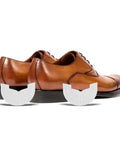 Rubber Shoe Heel Repair Pads 4mm White 1 Pair placed near brown dress shoes, enhancing traction and silence while walking.
