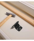 Adjustable Self Closing Hidden Spring Cabinet Door Hinge In Black Finish, shown uninstalled on white surface, with hammer nearby