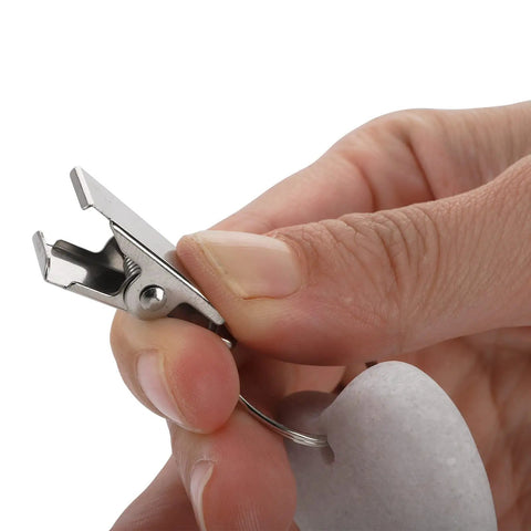Close-up of stainless clip and white heart stone from 12 Pieces White Heart Shaped Stone Tablecloth Weights With Metal Clips For Indoor Outdoor Use Keeps Table Covers Flat At Picnics And Hangouts Durable Marble Feel Decor.