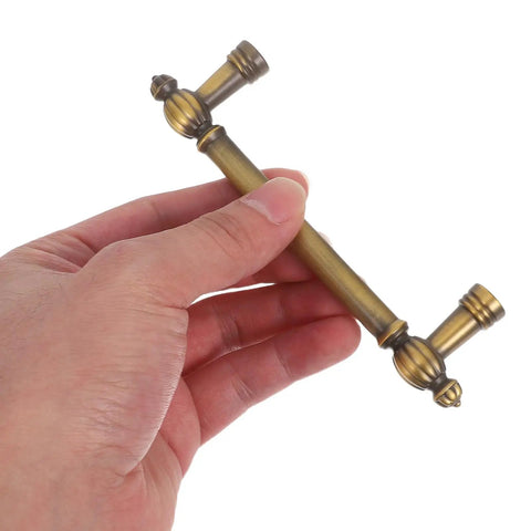 Hand holding vintage zinc alloy cabinet pulls and drawer handles two pack solid metal retro heavy duty door hardware 96mm hole spacing