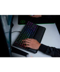Classic Black Tenkeyless Mechanical Gaming Keyboard With Tactile Orange Switches And Smooth RGB Backlighting featuring wrist rest in use.
