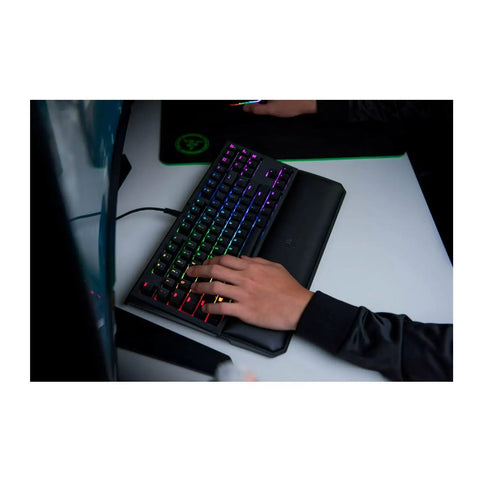Classic Black Tenkeyless Mechanical Gaming Keyboard With Tactile Orange Switches And Smooth RGB Backlighting featuring wrist rest in use.
