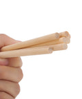 Premium Unfinished Natural Wood Dowel Rods 100 Pack Of Six By One Quarter Inch Smooth Cylinders held in hand for arts and crafts.