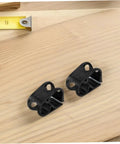 Two black adjustable tube pinch valve clamps for lab tubing, flow control clips for liquids on wooden surface with measuring tape.