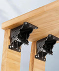 Close-up of Heavy Duty Four Piece Folding Brackets For Table And Bed Legs With Self Lock Hinge Hardware on wood.