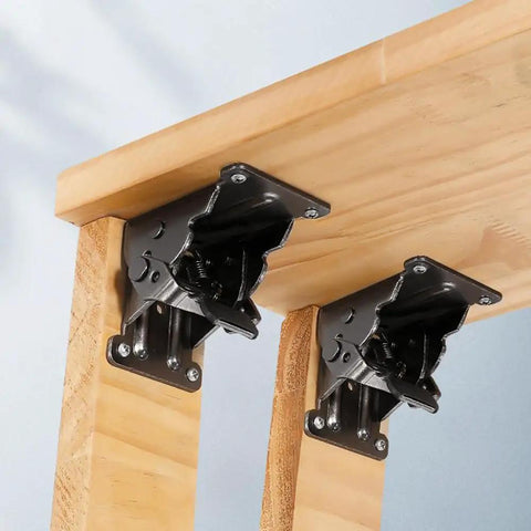 Close-up of Heavy Duty Four Piece Folding Brackets For Table And Bed Legs With Self Lock Hinge Hardware on wood.