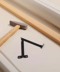 Antique Style Iron Folding Lid Hinges With Handy Fold Out Support Legs for boxes, shown with hammer on beige surface