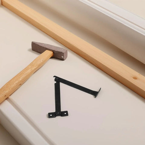 Antique Style Iron Folding Lid Hinges With Handy Fold Out Support Legs for boxes, shown with hammer on beige surface