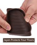 Hands holding brown Square Rubber Furniture Caster Cups With No Slip Grip, Stay Put Anti Movement Pads for floor protection.