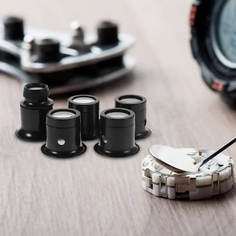 Five Piece Jewelers Loupe Set With Holder 3X 5X 10X 15X 20X Monocular Magnifiers on table with watch gears