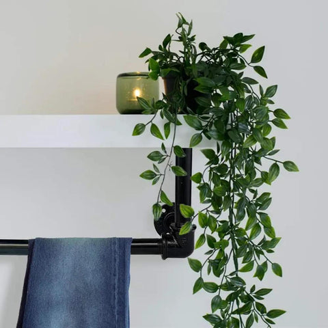Black steel pipe used in DIY shelving with greenery and candle for industrial decor. Fits standard three-quarters inch black threaded fittings.