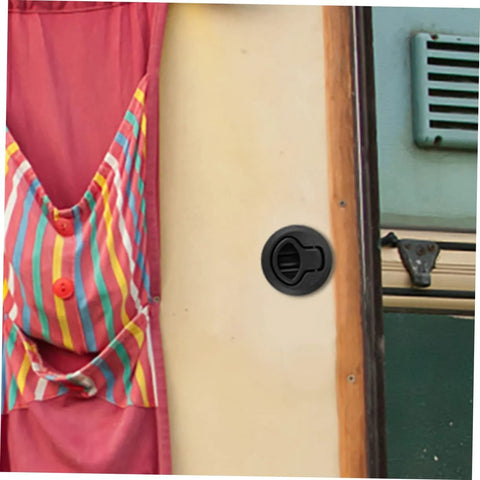Round black flush pull slam latch installed on boat/RV cabinet panel