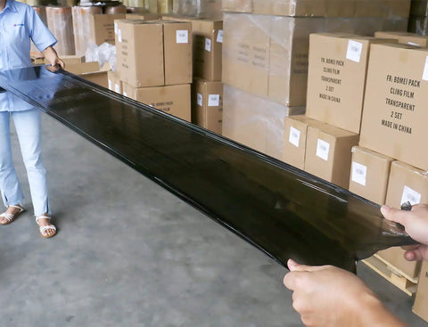 Heavy Duty Black Stretch Wrap 1500 Ft Roll With Hand Saver Handles 15 Inch Wide 70 Gauge Shrink Film shown in use for moving.